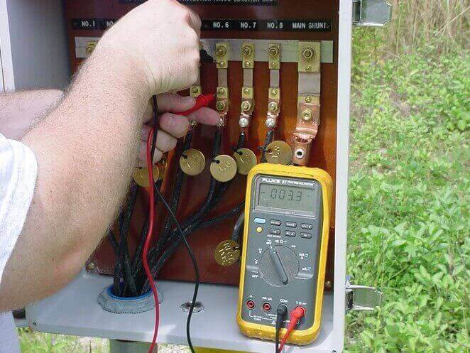 a corrosion engineer operates a meter at a jobsite